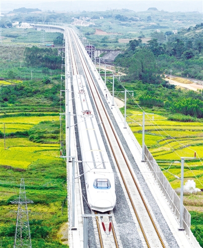 　12月3日，一輛試運行的“和諧號”列車從廣西南寧市隆安縣境內(nèi)的一座高架橋經(jīng)過。韋萬忠攝（新華社發(fā)）