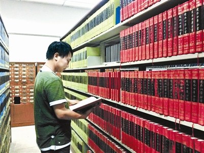 資料圖：一名古籍愛好者正在北大古籍閱覽室翻看“四庫全書”。圖片來源：北京青年報