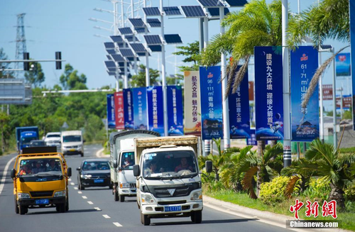 6月24日，海南省文昌市旅游大道的太陽能路燈桿上懸掛著火箭“首發”宣傳廣告。長征七號運載火箭發射日期臨近，中國首個濱海航天發射中心——文昌航天發射場所在地海南省文昌市龍樓鎮將迎來“首發”，中國的“卡納維拉爾角”正揭開神秘面紗。中新社記者 駱云飛 攝