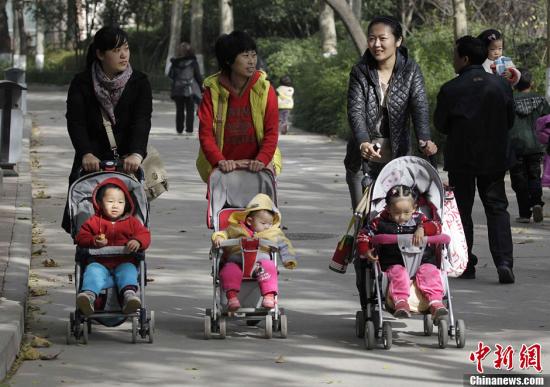 資料圖：2013年11月15日，河南鄭州幾位家長推著嬰兒車走過鄭州街頭。中共十八屆三中全會審議通過了《中共中央關于全面深化改革若干重大問題的決定》，《決定》提出，啟動實施一方是獨生子女的夫婦可生育兩個孩子的政策。<a target='_blank' href='http://www.chinanews.com/'>中新社</a>發(fā) 王中舉 攝