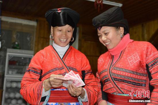 1月27日，廣西龍勝各族自治縣龍脊鎮(zhèn)大寨村的瑤嫂正在清點(diǎn)分到的梯田維護(hù)費(fèi)。1月27日至1月28日，廣西龍勝各族自治縣龍脊鎮(zhèn)大寨村村委會(huì)將110多萬(wàn)元的“紅利”分發(fā)到200多戶的群眾手中。龍脊鎮(zhèn)大寨村從2003年開(kāi)寨接待游客以來(lái)，該縣通過(guò)旅游扶貧方式引導(dǎo)該村群眾以梯田入股方式與當(dāng)?shù)氐凝埣孤糜喂韭?lián)營(yíng)，旅游公司則將門(mén)票收入按一定的比例為當(dāng)?shù)氐拇迕癜l(fā)放梯田維護(hù)費(fèi)。目前，大寨村的游客多了，大部分村民開(kāi)設(shè)了農(nóng)家旅館，和販賣(mài)瑤族工藝品等，使其成為當(dāng)?shù)厝罕娫鍪罩赂坏闹饕馈?lt;a target='_blank' href='http://www.chinanews.com/'>中新社</a>發(fā) 韋吉陽(yáng) 攝