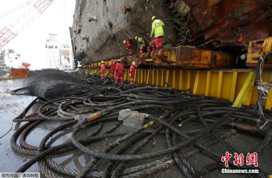 當?shù)貢r間3月27日，韓國珍島工人正在移除“世越號”船體上的電線。日前沉沒近3年的韓國“世越號”船體已經(jīng)被抬出水面。