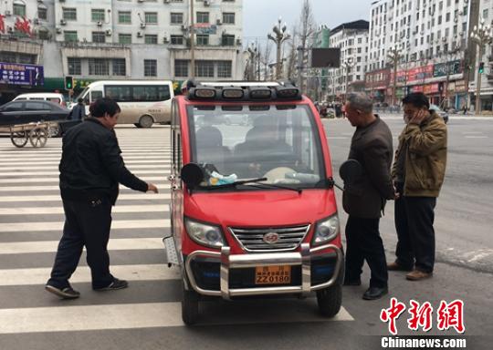 營山城區(qū)電動四輪車司機正在討論車輛的車況。　劉忠俊 攝