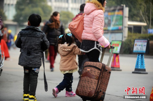 資料圖：2015年2月5日，2015年春運第二天，江蘇揚州市汽車西站迎來客流高峰，圖為家長帶著孩子在江蘇揚州市汽車西站候車。 孟德龍 攝