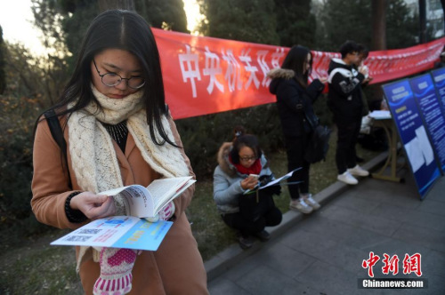 資料圖：2016年11月27日，山西太原一國考考點(diǎn)，考生在考場外看書復(fù)習(xí)。武俊杰 攝