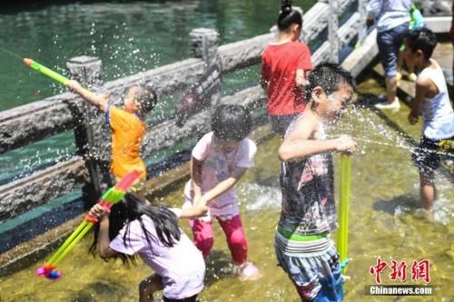 7月11日，幾名兒童在山東濟南“清泉石上流”池中戲水納涼。