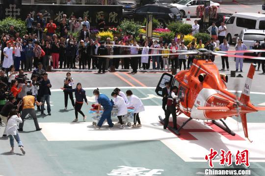 5月23日，遼寧省人民醫(yī)院完成中國(guó)東北首例異地航空醫(yī)療轉(zhuǎn)運(yùn)任務(wù)。圖為急救人員立即將患者抬上急救床。　朱明宇 攝