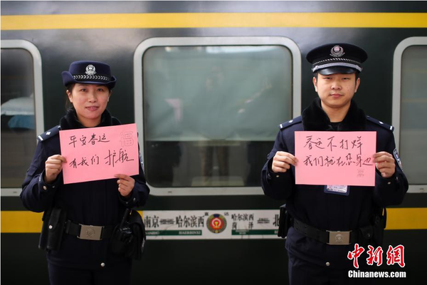 2月1日，隨著春節(jié)臨近，南京鐵路公安處南京站派出所的民警在紙上寫(xiě)下“平安春運(yùn)，有我們護(hù)航”、“天下無(wú)賊是我們最大的心愿”、“平安歸途么么噠”等話語(yǔ)，用別樣的方式給旅客們送上溫馨的新年祝福。圖為南京火車站站臺(tái)上的值班民警送出溫馨祝福語(yǔ)。中新社記者 泱波 攝