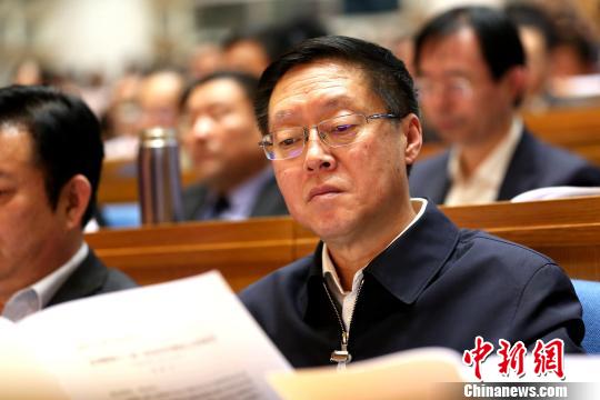 圖為與會政協委員在現場閱讀會議文件。　梁犇 攝