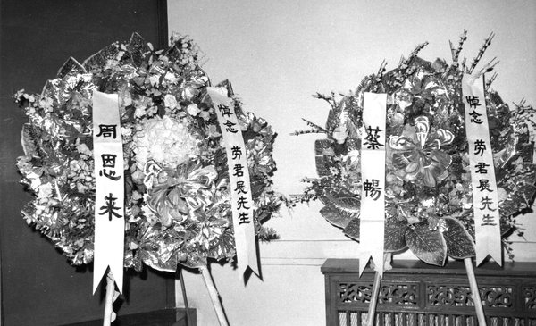 9--1976年1月8日，在勞君展先生追悼會的會場上，擺放著全國政協周恩來主席所獻的花圈