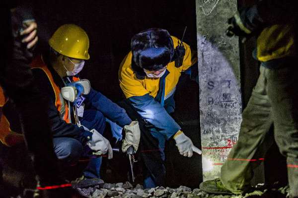 機械工隊長侯寧與03506清篩車組車隊長核對清篩后的線路標高，嚴把施工質量關。（攝影 賈佳）