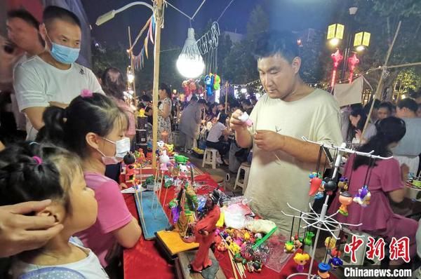 資料圖：圖為手工藝人在夜晚走上街頭，展示面塑工藝。　趙曉 攝